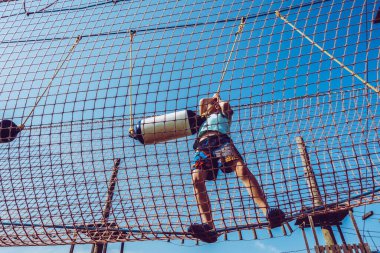 Çocuk ip parkında oynuyor.