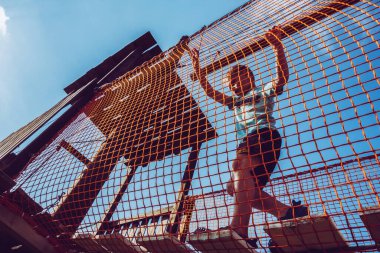 Çocuk ip parkında oynuyor.