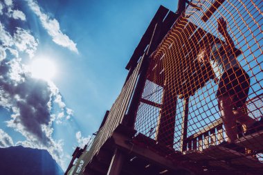 Çocuk ip parkında oynuyor.