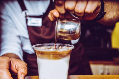 Barista kafenin arka planında kahve yapıyor.