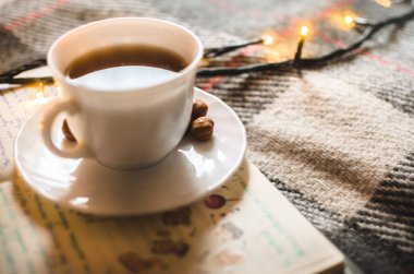İronik ve sıcak bir atmosferde sıcak siyah çay çelenk, Noel atmosferi, sabah ışığı.