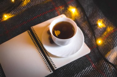  Kışın ya da soğuk sonbaharda evde çelenkli fındıklı bir fincan sıcak çay ve Noel atmosferinin sıcak fotoğraflarını içeren bir çelenk ve defterle sıcak bir araya gelmek.