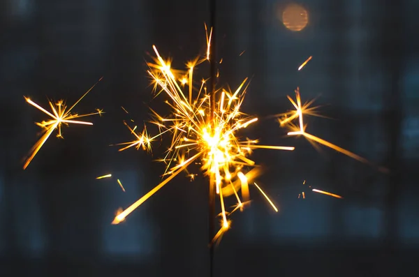 Chispas para Navidad y Año Nuevo de cerca y sobre un fondo azul — Foto de Stock