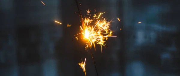 Chispas para Navidad y Año Nuevo de cerca en forma de una pancarta y sobre un fondo azul — Foto de Stock