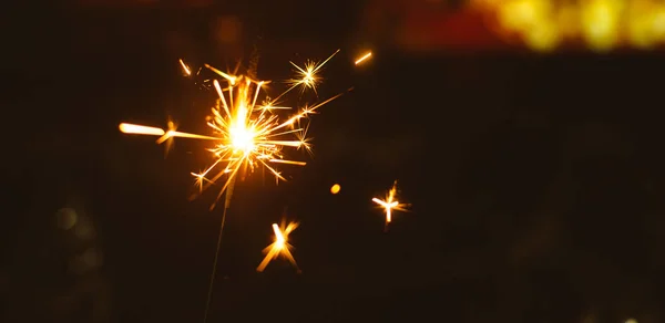 Gnistor för jul och nyår närbild på en semester bakgrund i varma färger, brett foto — Stockfoto