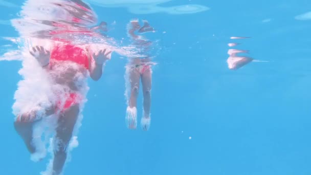 Fröhliche Spaß liebende Gruppe von Freunden, die ins Schwimmbad springen. Unterwasserblick — Stockvideo