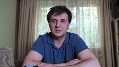 Evde çalışan bir adam video konferans görüşmesi yapıyor.