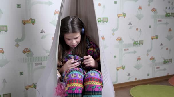 Підліток грає в онлайн ігри на телефоні вдома . — стокове відео