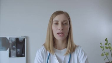 Genç bayan doktor kamerayla konuşuyor.