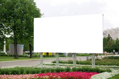 büyük beyaz boş afiş reklam için şehir parkına yakın plan doğa ve çiçeklerin arka planı
