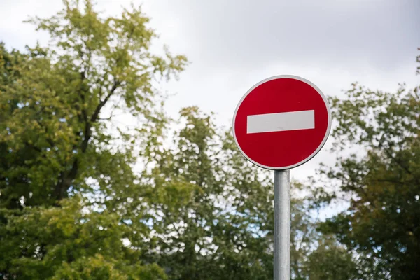 Żelaza czerwony Nie wpisuj pusty znak zbliżenie na zamazanym tle nieba, drzew — Zdjęcie stockowe