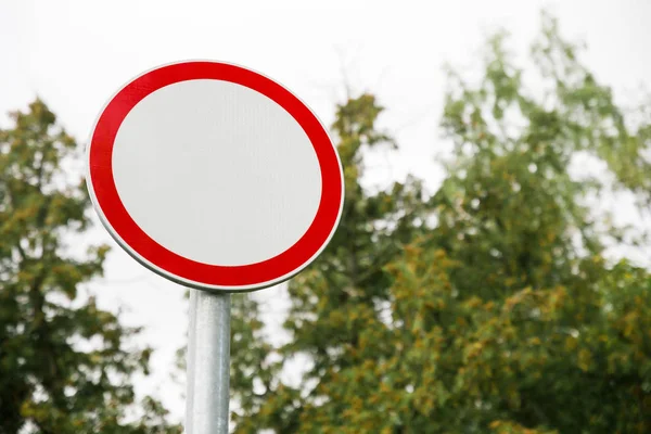 White with red border empty road round sign close up on blurred background of sky and trees — 스톡 사진