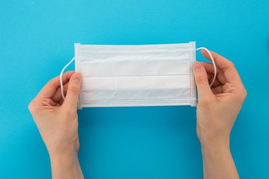 Ellerindeki birkaç tıbbi maskenin en üst görüntüsü. Tek kullanımlık doktor solunum cihazı. Mavi bir arkaplanda izole edilmiş