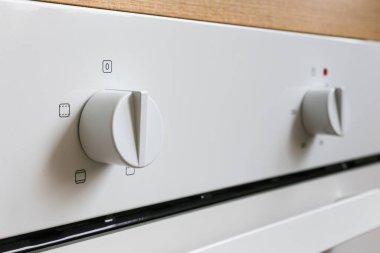 Beyaz elektrikli fırın düğmeleri. Modern mutfak aletleri için kontrol düğmeleri. Yakın plan, perspektif açısından.