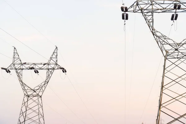 Elektrik kablo iletişim kuleleri günbatımı üzerinde.