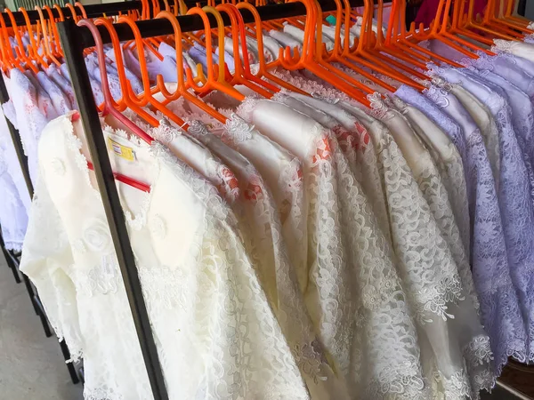 Many white blouses on hangers in the dressing room. — Stock Photo, Image