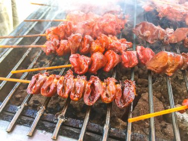 Dumanlı bir metal ızgara ızgara tavuk.