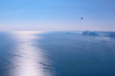 Norveç denizinde kutup günü. Norveç denizinin su yüzeyindeki helikopterin kokpitinden görüntüyü al. Deniz yüzeyinde batan güneşin parlaklığı.