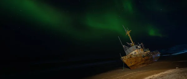 星空の中の極光 漁船が横になり バレンツ海の岸の嵐で流された ロシアのテリベルカ — ストック写真