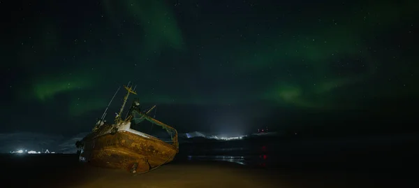 星空の中の極光 漁船が横になり バレンツ海の岸の嵐で流された ロシアのテリベルカ — ストック写真