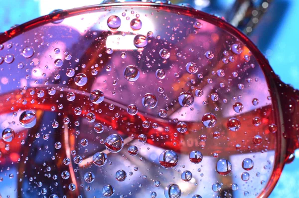 shiny clear water point attached to a glass reflects the same color as the color on the glass into a beautiful background as decoration