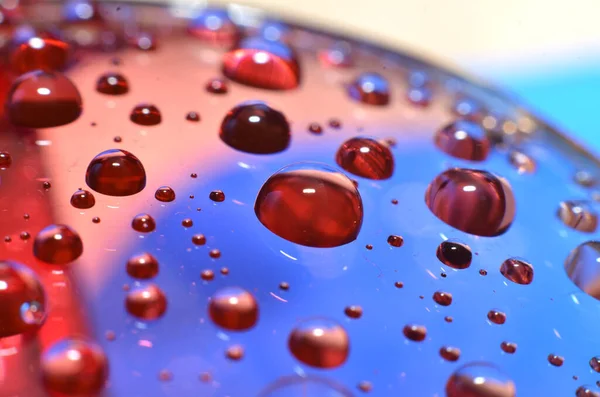 shiny clear water point attached to a glass reflects the same color as the color on the glass into a beautiful background as decoration