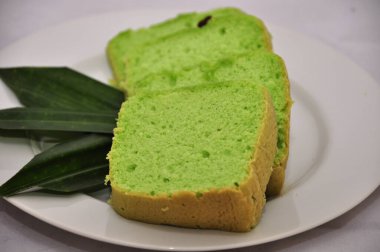 Yeşil çay aromalı sünger tadında açık yeşil ekmek üzerinde kuru üzüm tohumu ve düz beyaz bir grup.