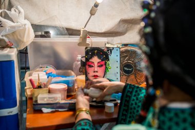 Teochew Operası. Sanatçı makyaj yapıyor. Geleneksel miras sanatı.
