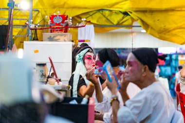 Asya Çin lehçesi, Teochew Operası. Sanatçı makyaj yapıyor. Geleneksel miras sanatı.