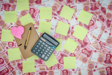 Çin Çin Yuan para birimi 100 dolar banka arka plan olarak para not. Yazı için boş sarı yapışkan kağıt etiketi. Güneş enerjili hesap makinesi, geri dönüştürülmüş not defteri kalem..