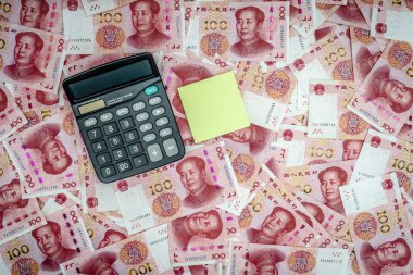 Çin Çin Yuan para birimi 100 dolar banka arka plan olarak para not. Hesap makinesi, sarı yapışkan nesne izole edildi.