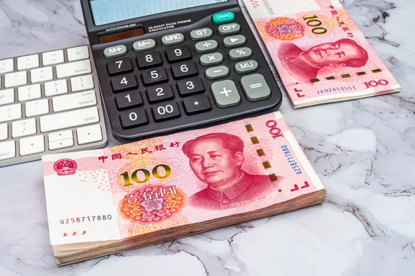 Koncepcja biznesu finansowego. Stos Chin chińskich banknotów Yuan Rmb, kalkulator i klawiatury na stole. — Zdjęcie stockowe