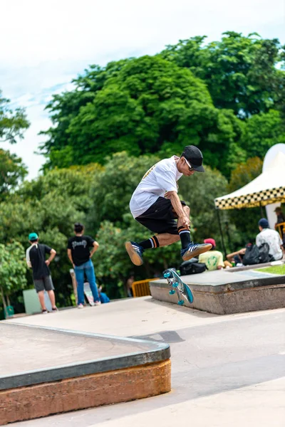 Jovem asiático menino patinador exibindo prancha patinação habilidades ao ar livre no skatepark — Fotografia de Stock