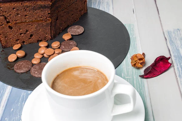 Австрийский шоколадный торт с тонким слоем абрикосового джема и чашкой кофе . — стоковое фото