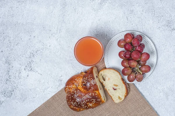 Pequeno-almoço na mesa. Conceito de leigos planos. Uvas no prato, pão e uma xícara de suco de toranja . — Fotografia de Stock
