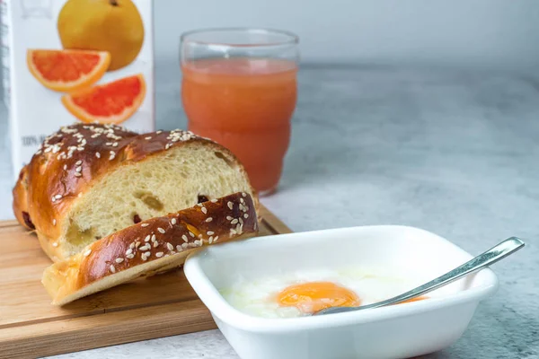 Breakfast brunch concept. Home-baked raisins bread, soft-boiled eggs and grapefruit juice on table. — Stock Photo, Image