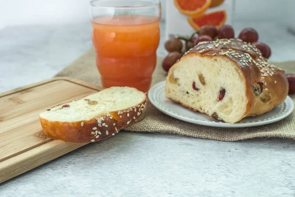 Healthy breakfast and brunch on table concept. Home-made raisins bread, cup of grapefruit juice and grapes. — Stock Photo, Image