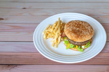 Domuz pastırmalı, peynirli, marullu, domatesli ve patates kızartmalı Jumbo biftekli burger.