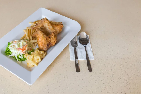 Nahaufnahme von zwei gebratenen Chicken Wings, Pommes, mit Macs & Käse und frischem Krautsalat auf grünem Salat — Stockfoto