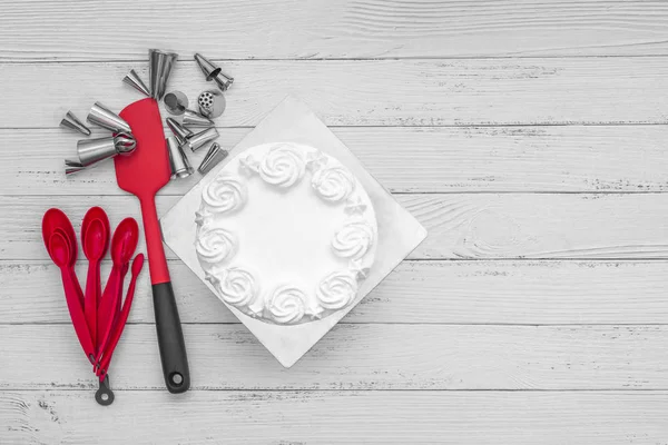 White cake frosting with baking accessories utensils on table, flat lay one white background