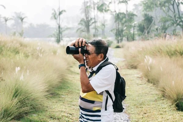 Asiatisch chinesisch reif männlich taking outdoor photos mit digital dslr kamera — Stockfoto