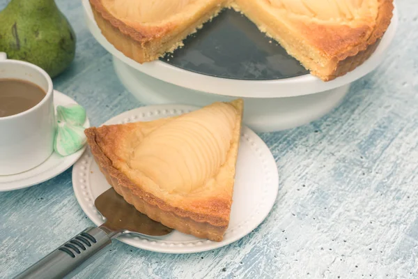 Delicious home bake poached pear tart pie, as known as Tarte Bourdaloue, a cup of coffee latte. It is a french popular recipe that gets the name from a street in Paris. Food on table concept. — Stock Photo, Image