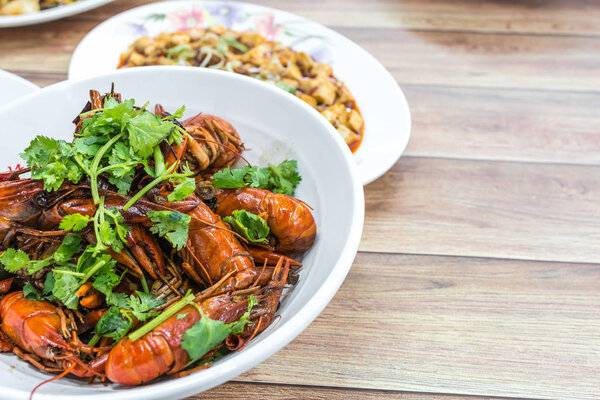 Чунцин Сычуань пряные сушеные чили мелкие омары, среди других блюд на заднем плане. Фотография еды в китайском ресторане
.