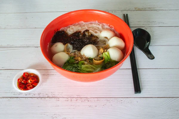 Asia Singapur fideos con bola de pescado sopa de vermicelli carne de cerdo picada con corte de chile rojo padi, verduras verdes, y fresco frito ikan billis peces . — Foto de Stock