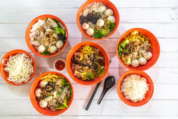 Flat lay top down view of assorted Singapore street food. Dry and soup noodles.