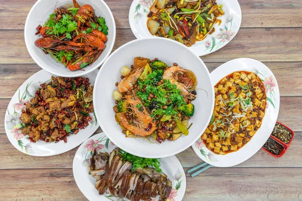 Otantik Çin yemeği, Sichuan yemeği masasının üstünde yatıyordu. Geleneksel yemekler, mis kokulu güveç, kızarmış tavuk, mini ıstakoz, baharatlı fasülye ezmesi, mapo doufu.