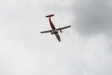 Bulutlu bir günde gökyüzünde uçan ticari uçağın dipteki görüntüsü