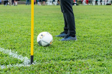 Futbol sahasının köşesinde topa vurmak üzere olan tanınmamış bir erkek futbolcu.
