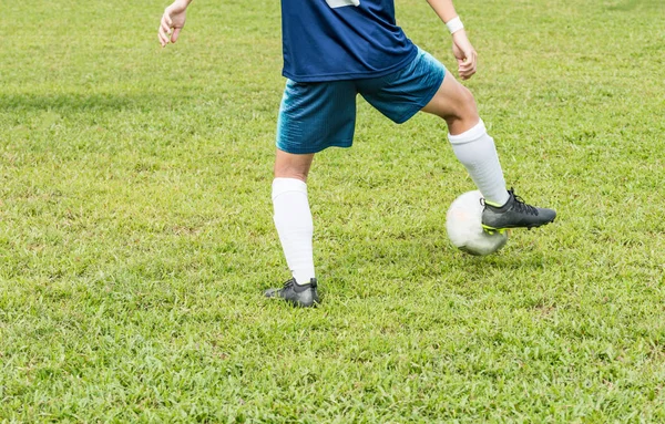 Dolny widok pleców niezidentyfikowanego piłkarza w kolorze niebieskim na boisku do piłki nożnej. Zatrzymuje piłkę prawą nogą.. — Zdjęcie stockowe