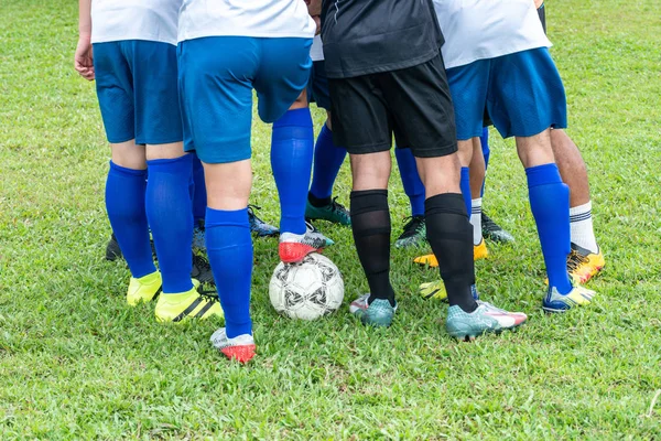 Football players gathered in circle before the match to raise team spirit and cheer each other. Soccer team on the field ready to play in a tournament. Selective focus. — Stock Photo, Image